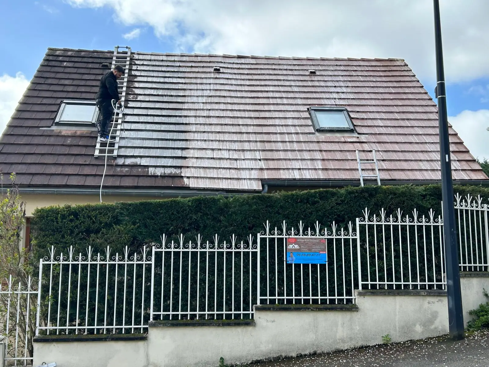 Nettoyage haute pression d'une toiture en tuiles plates, la moitié du versant déjà décapée — RW Couvreur